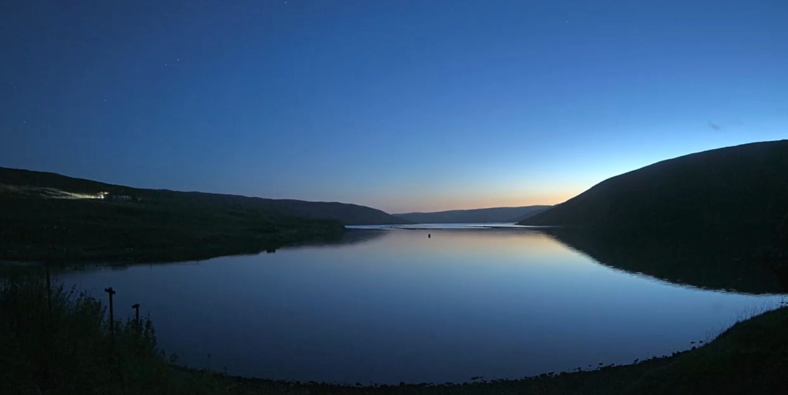 A view over a voe (a bit like a Norwegian fjord, just Shetland/Orkney in origin) showing the sunset in late August, reflecting on the water.