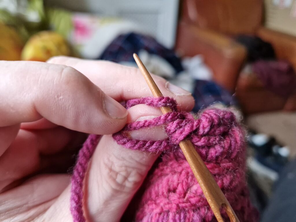 Now under the top thumb loop and the loop behind the thumb.